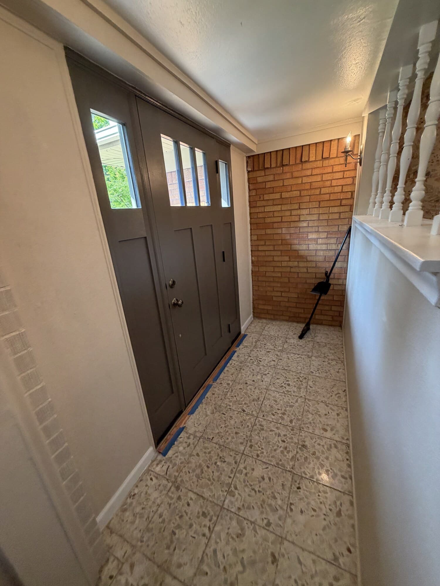 Interior of the front door with the sidelight, looking toward the porch railing