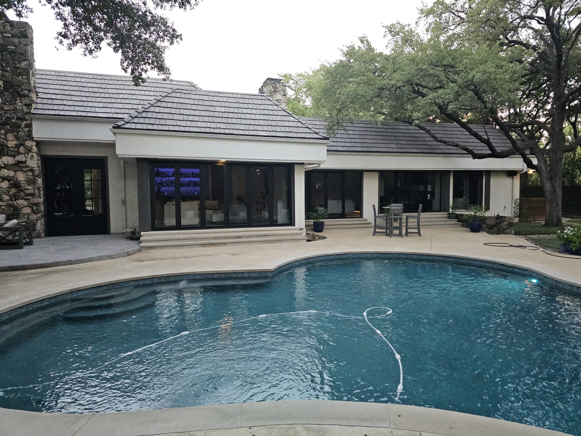 Rear elevation showing the completed multi-slide system with the pool in the foreground