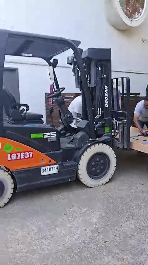 A forklift lifting crated door units off a delivery at the job site