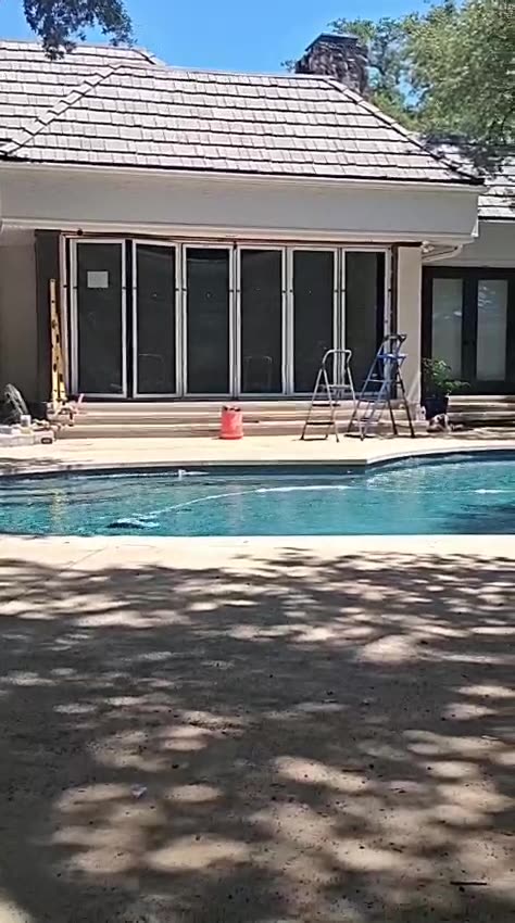 The completed multi-slide door system along the rear elevation beside the pool